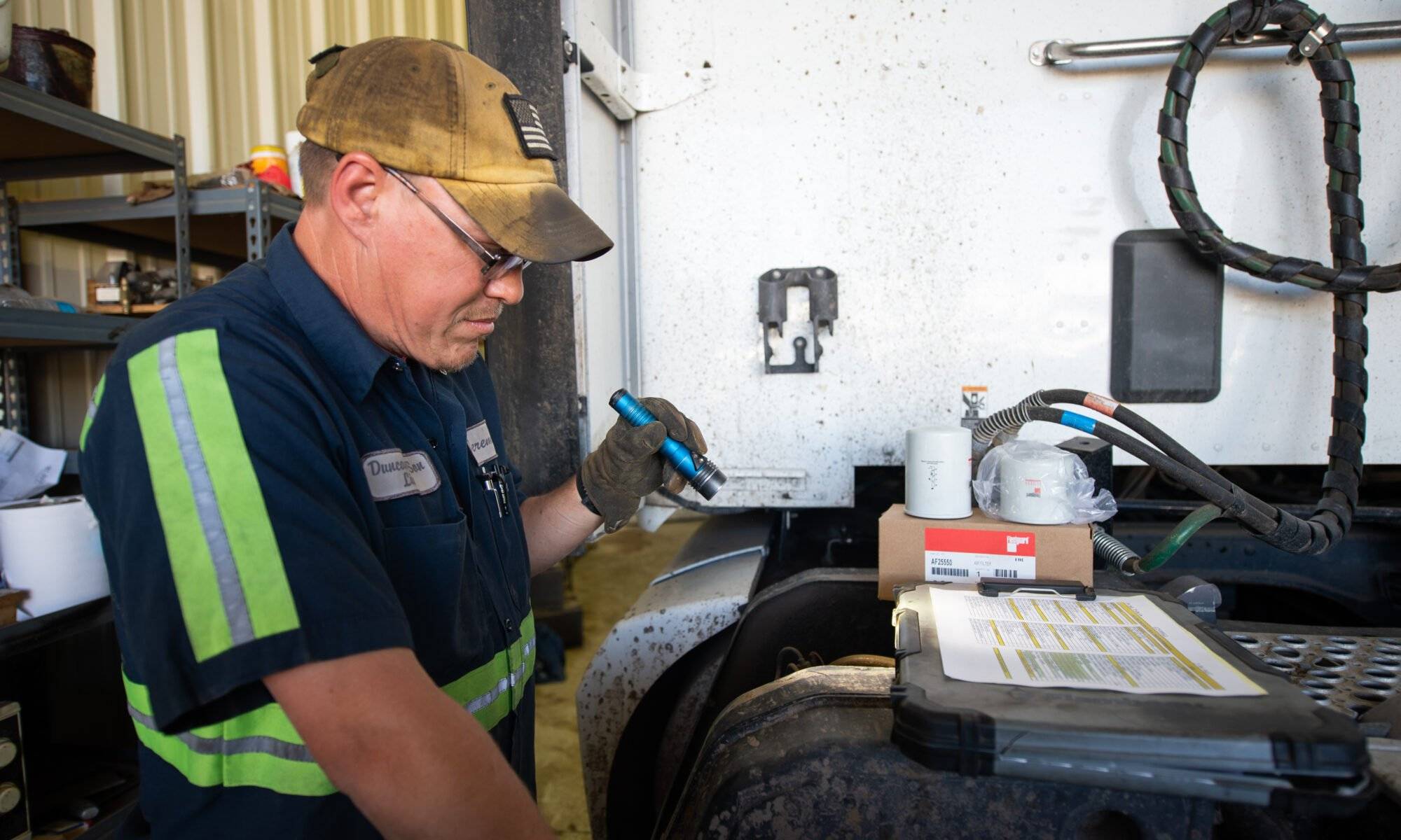 CDL driver in Phoenix, AZ inspecting truck tires during a pre-trip inspection to ensure road safety and compliance.